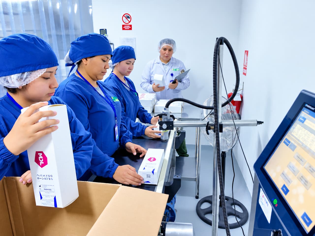Operarias acondicionando y codificando estuches en la línea de producción